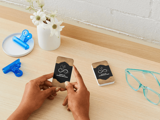 NEW WAVE SPEAK LIFE AFFIRMATION CARDS BUILD YOUR FAITH prayer cards displayed on a wooden desk with a person holding one card and a stack nearby. Ideal for daily Christian inspiration and faith-building routines.